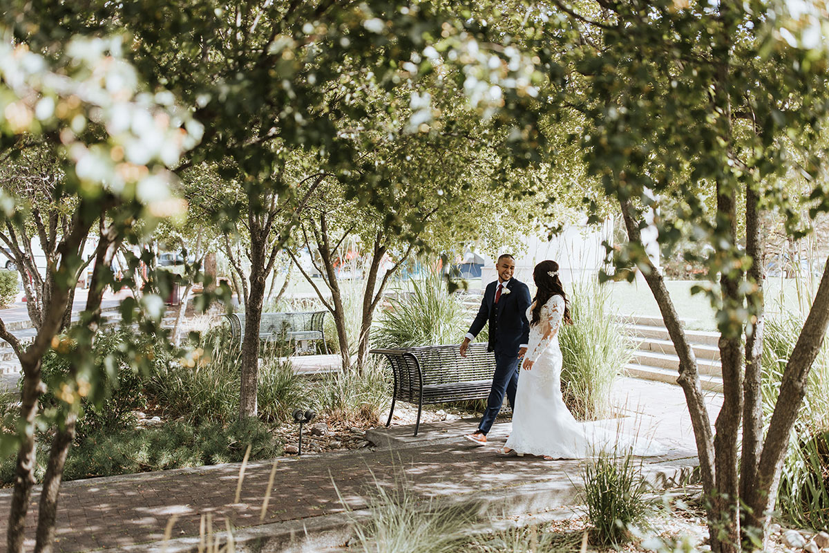 Couple dressed for wedding walking through garden