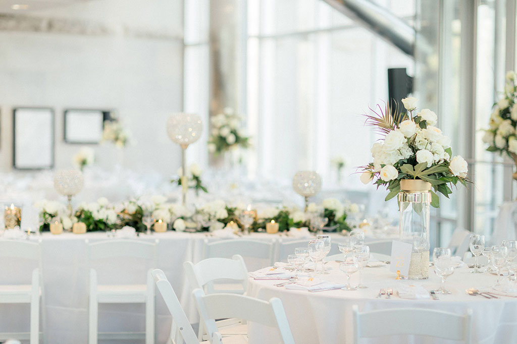 An elegant wedding reception at The Cable Center with white tables and flowers.